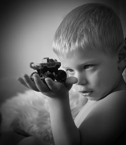 Close-up portrait of shirtless boy holding camera