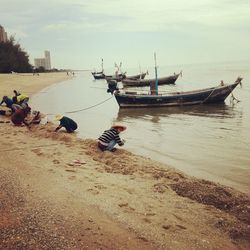 Boats moored on beach against sky