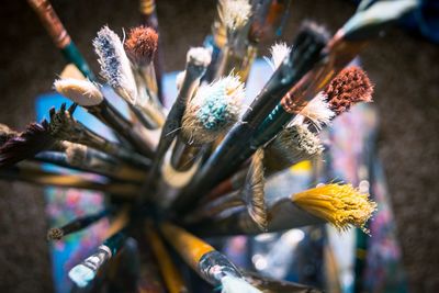 Directly above shot of paintbrushes in container on table