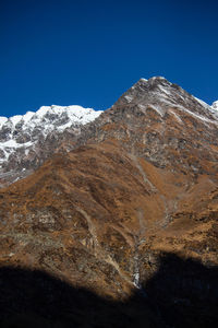 Scenic view of snowcapped mountains against clear blue sky