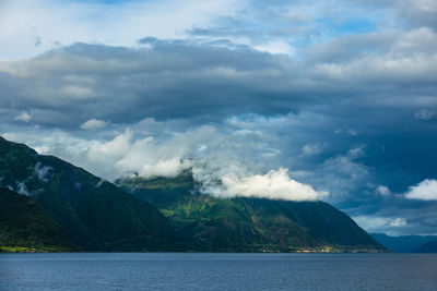 Scenic view of sea and mountains against sky