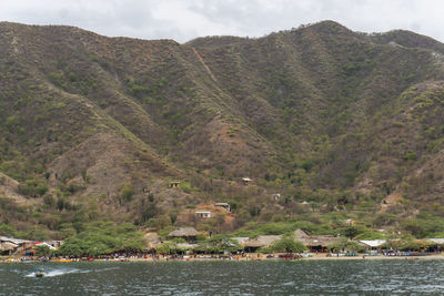 Scenic view of lake by mountains against sky