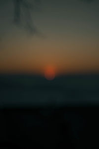 Defocused image of sea against sky at sunset