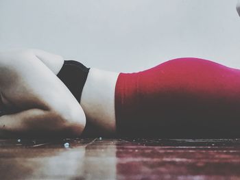 Close-up of woman lying down on table against white background