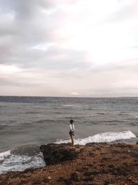 Man standing on beach against sky