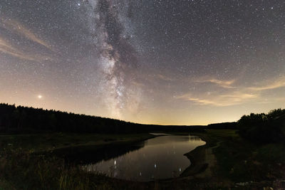 Scenic view of lake against sky at night