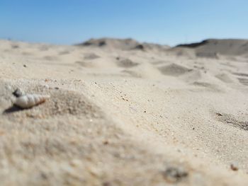 Scenic view of sand dunes against clear sky