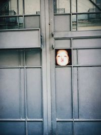 Portrait of cute boy peeking through window