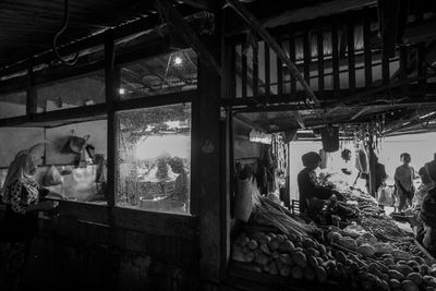 People in market seen through window