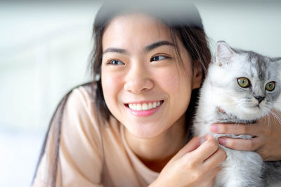 Portrait of young woman holding cat