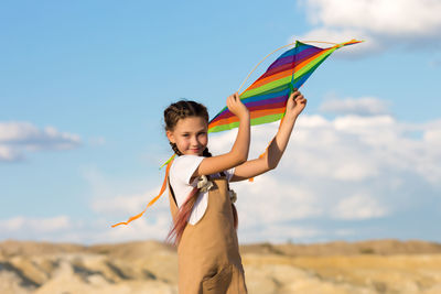 A girl of 8-9 years old launches kite into the sky.