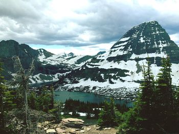 Scenic view of snow covered mountains against cloudy sky