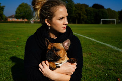 Woman embracing dog on field