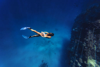 Adventurous woman diving underwater in sea