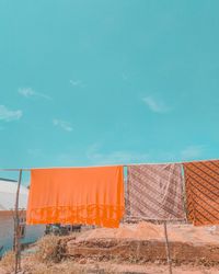 Low angle view of orange building against blue sky