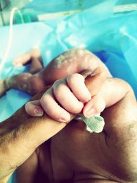 Close-up of father holding baby hand