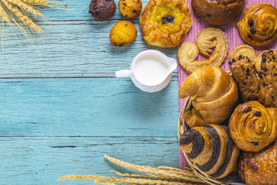 Close-up of croissants with pitcher on table