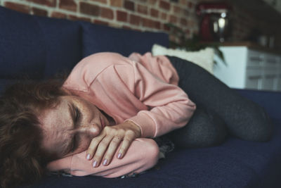 High angle view of woman lying on sofa at home