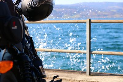 Close-up of camera on railing against sea