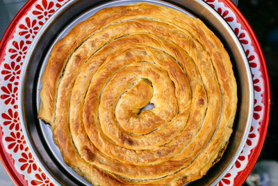 Close-up of baked pasty item in container