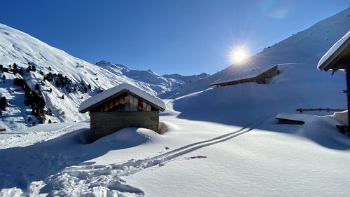 Snow covered landscape and houses against sky