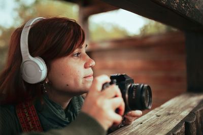 Close-up of woman looking away while photographing with camera