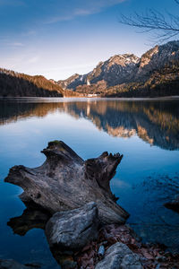 Scenic view of lake by snowcapped mountains against sky