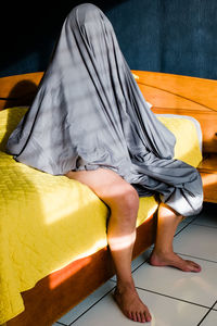 Midsection of woman sleeping on bed