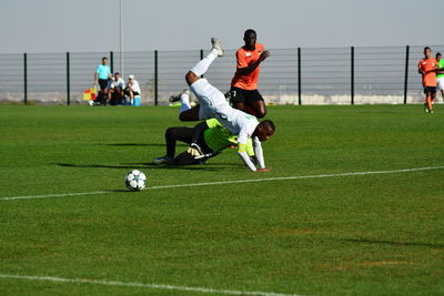 Men playing soccer on field