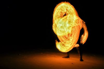 Man spinning wire wool at night