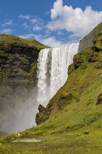 Scenic view of waterfall against sky