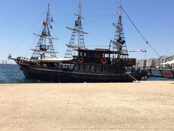 Sailboats moored in sea against clear sky