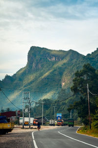 Road by mountains against sky