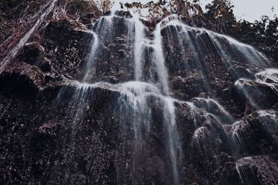 Low angle view of waterfall against sky