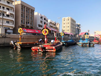 Boats in canal against buildings in city