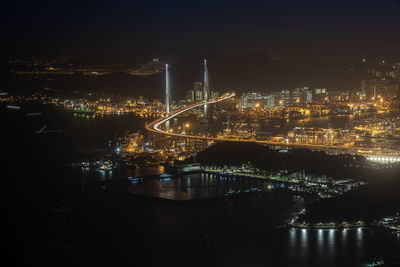 High angle view of illuminated city by river at night