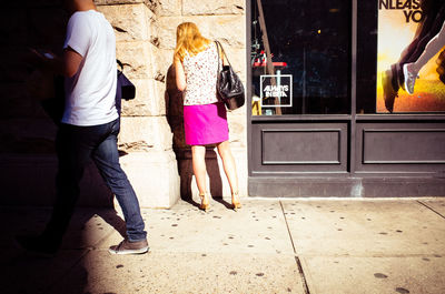 Full length of woman walking on sidewalk