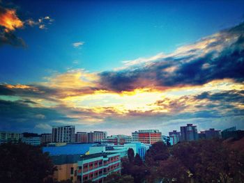 Buildings against cloudy sky at sunset