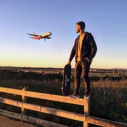 Airplane flying over landscape against clear sky