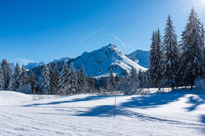 Scenic view of snow covered mountains against cloudy sky