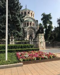 Flowers growing outside temple against clear sky