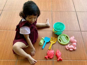 High angle view of girl sitting on floor