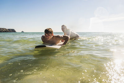 Teenage couple on surfboard in the sea