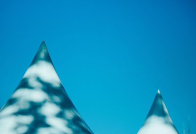 Low angle view of tents against clear blue sky