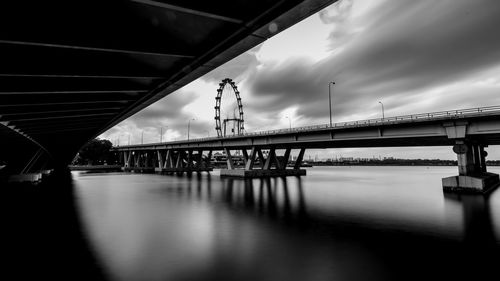 Bridge over river against cloudy sky