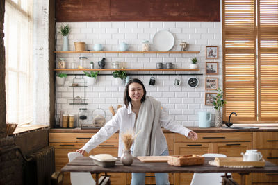 Portrait of smiling woman standing at home