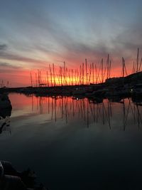 Silhouette sailboats on lake against sky during sunset