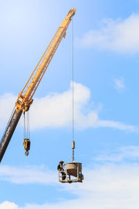 Low angle view of crane against sky