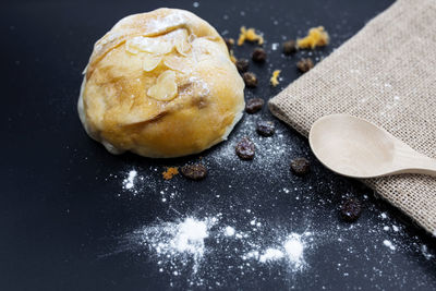 Freshly backed currant sourdough bread, top view. artisan bread with seeds on black table.