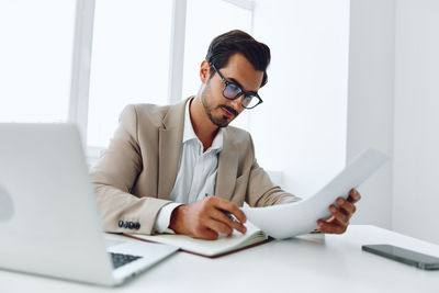 Businesswoman using laptop at desk in office